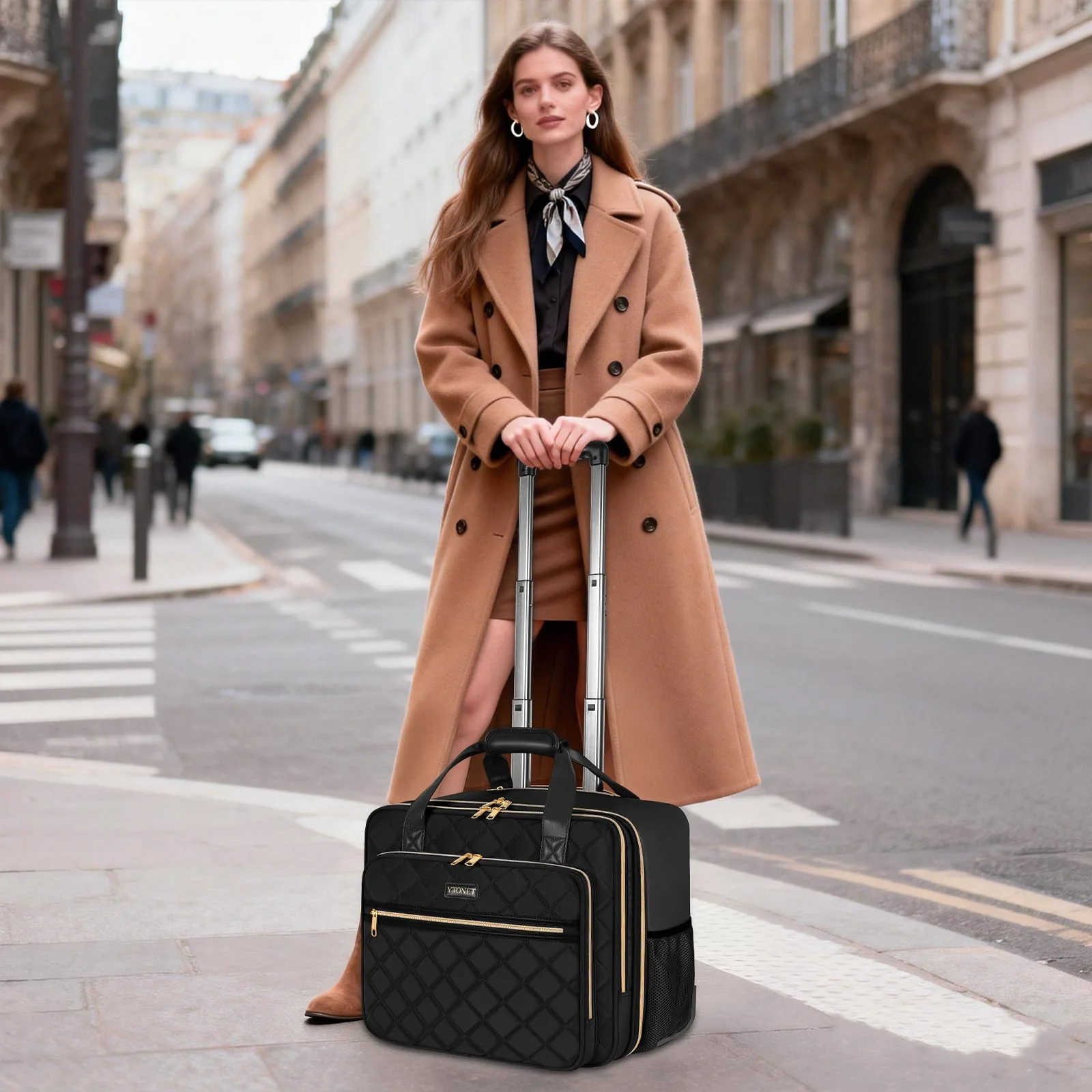 A black quilted 17.3-inch rolling laptop bag pulled along a Paris street by a woman in a camel coat