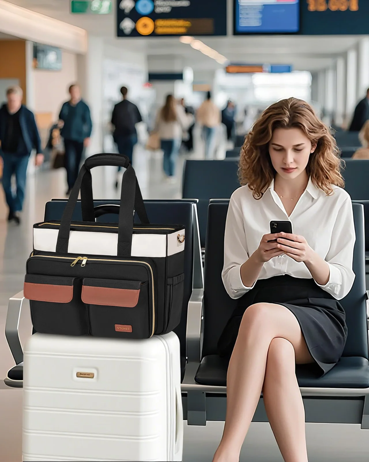 A black and cream teacher tote riding on the handle of a white suitcase at an airport gate